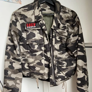 militärgrön jacka - höst/vår/svensk sommarjacka, skönt material, 4 fickor på framsidan, röd text, gillar den verkligen men har använt några gånger bara