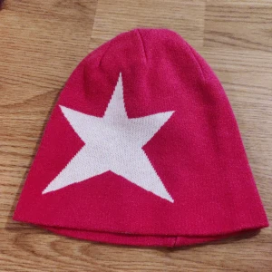 Rosa mössa - En rosa mössa med en vid stjärna på och man kan vända den ut och in