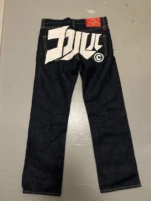 by Lou jeans - by Lou jeans  Strl 28, passar ungefär 30x32  Riktigt feta jeans med straight passform. Coolt tryck över bakfickorna och i övrigt snygga detaljer. Även väldigt bra skick!  Kan passa både man&kvinna  Pris: 750kr +frakt