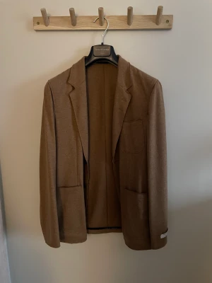 Tiger of Sweden Kavaj - Brun kavaj från tiger of Sweden, storlek 46 herr. Casual, kan användas som en jacka under våren och sensommar eller festlig aktivitet. Kavajen är oanvänd och lappen på armen finns kvar. Nypris 3500kr. Använd ej köp nu!