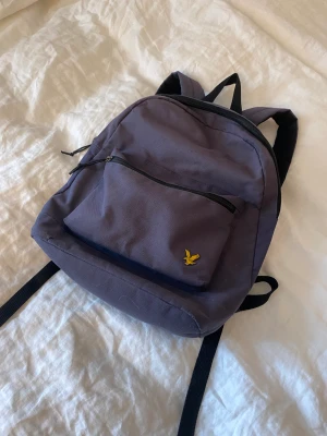Lyle and Scott ryggsäck - En mörkblå ryggsäck köpt på Lyle and Scott för ett par år sedan. Välanvänd men i väldigt fint skick! Ett litet fack plus det stora med några små innerfack. Frakten tillkommer, kram Ebba