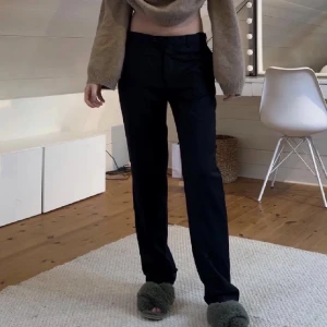 Lågmidjade kostymbyxor  - Säljer dessa lågmidjade kostymbyxor då de är för stora, jag har klippt en slits på byxan längst ner då jag ville kunna ha de över uggs💞passar 170 och i midjan går det att reglera men runt 70 cm i midjemåttet (lånad bild)
