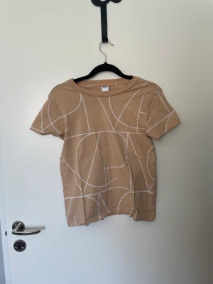 Beige MQ t-shirt - Säljer en beige t-shirt från MQ. Strl XS men passar både XS-S skulle jag säga.