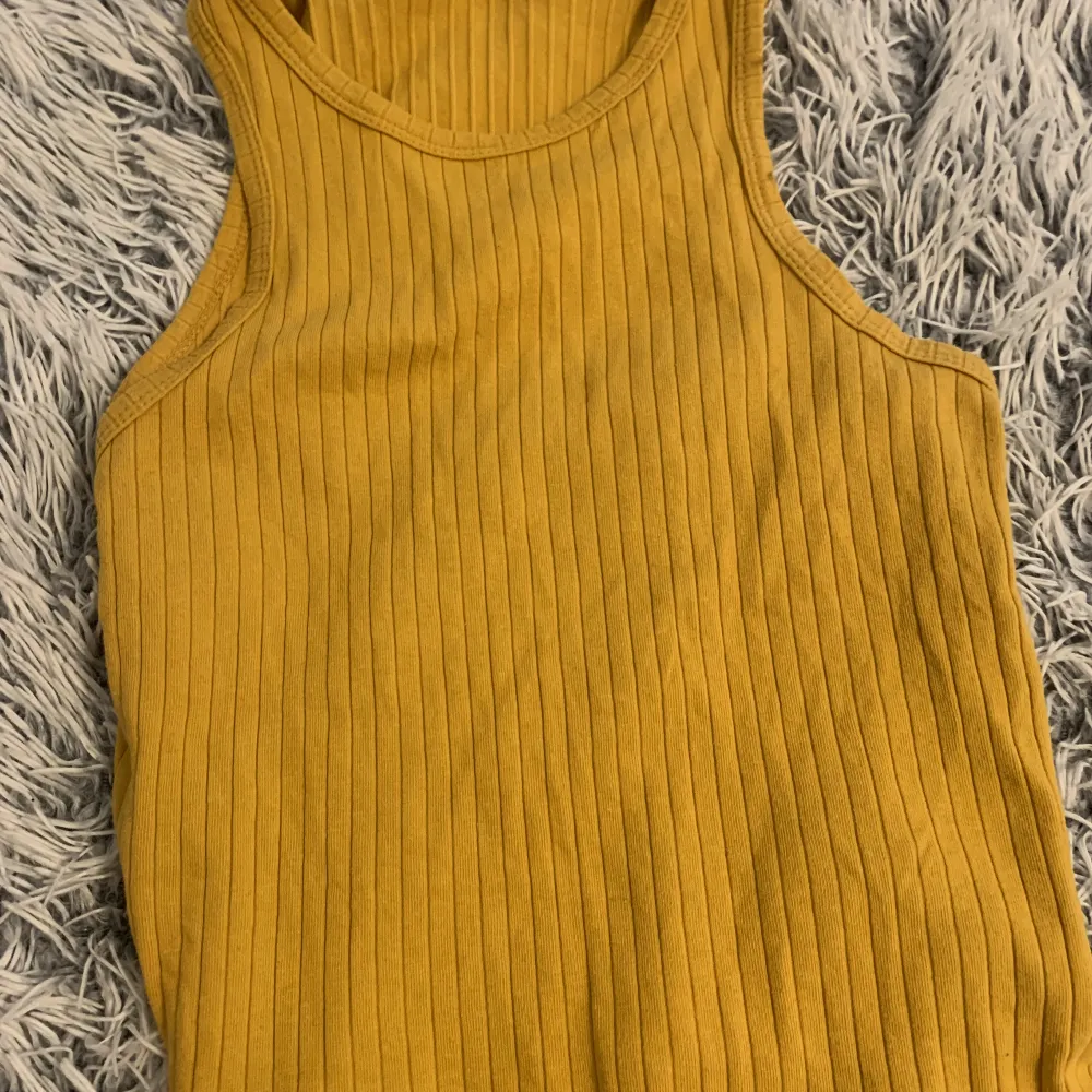 Ett gult linne, som har använt mycket under sommaren, den har blivit för liten därför så säljer jag den. Fin färg för sommaren . T-shirts.