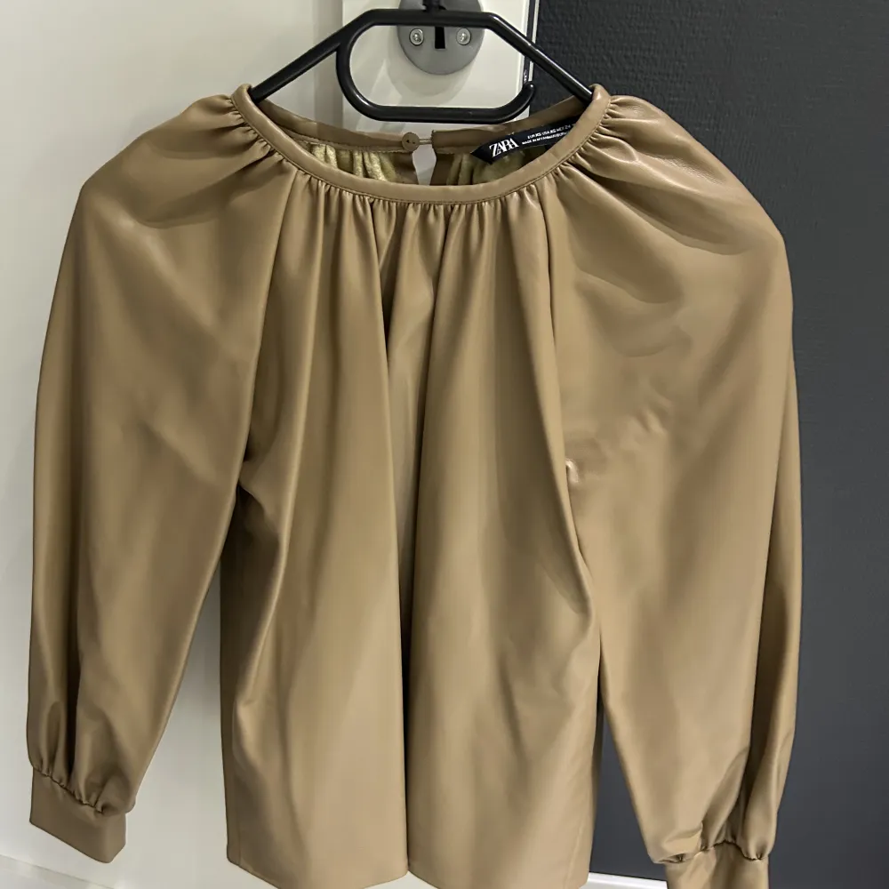 Skinn topp från Zara använd en gång, i fin beige färg.  Mycket bra skick, fick mycket bra kommentarer. . Toppar.