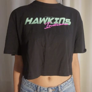 Cropped t-shirt med tryck  - Svart magtröja med tryck, H&M stranger things merch från 2019 använd men i bra skick 