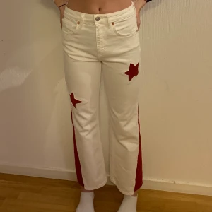 COOLA 70-TALS BYXOR - Vi säljer dessa coola jeans som vi har designat om. Från början var dem helt vita tighta jeans. Vi har lagt till en röd bit så dem blir med flared i passformen, vi har även lagt till röda stjärnor! Byxorna är välsydda och i mycket bra skick!  Frakt ingår💕