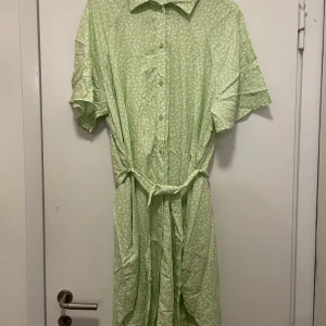 Grön klänning strl M - Aldrig använd.  En grön, blommig klänning från Monki.  Säljer pga felköp.