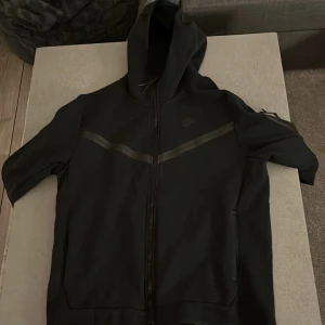 Nike Tech Hoodie - Tjena! Säljer nu min Nike hoodie då jag ångrar att jag köpte den och vill sälja den istället, den är använd ex antal gånger men fortfarande i väldigt fint skick och inga slitage eller något som är i sönder på den.  Ni får gärna höra av er om de är något!