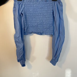Bik Bok blå off shoulder - En blå topp off shoulder, helt oanvänd med prislapp kvar. Ribbat stretchiga material  Kunden står för frakt, inga byten.