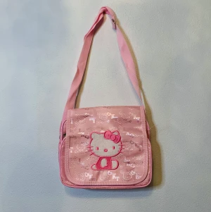 Rosa kawaii Hello Kitty hand väska - Supersöt Hello Kitty handväska! Helt ny och aldrig använd.  25cm bred 20cm djup.  Axelremmen är justerbar.   Passar perfekt till någon som älskar Hello Kitty  väskan är rymlig med ett fack fram och bak. 