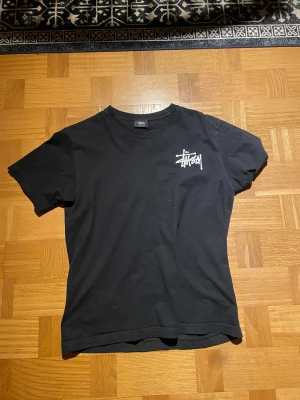 Stussy T-Shirt - Ganska sliten Stussy tisha, säljes därför med lågt pris🖤  Kan säljas billigare vid snabb affär