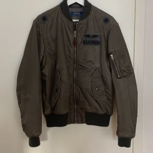 Polo Ralph Lauren bomberjacka - Polo. Bomberjacka. Grågrön, förbehandlad yta för vintage look.   Storlek M. Oanvänd.