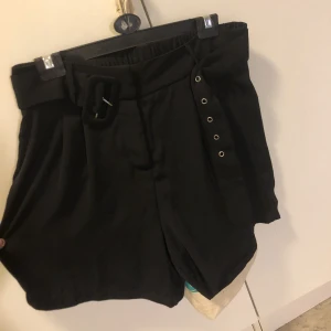 Svarta Shorts - INTE en kjol. Sällan använda. Väldigt lite stretch. Min midja är 77 cm och mina höfter är 105 cm, om du är större än det så kommer de troligen vara för små