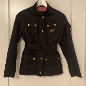 Barbour International Flyweight jacket - Barbour jacket. All buttons work and so does the zipper. There are 5 pockets total. Comes with a belt around the waist. It’s a children’s Large, if you wish for measurements contact me. Very lightweight jacket. In great condition.