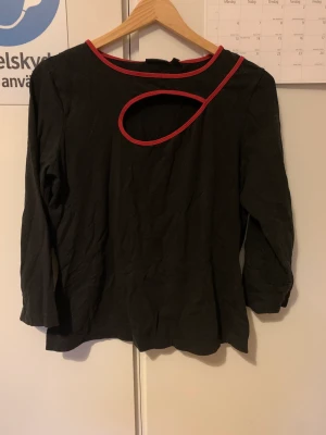 Svart trekvarts tröja med röda detaljer  - Fin tröja med 90/00 tals stil vibe.