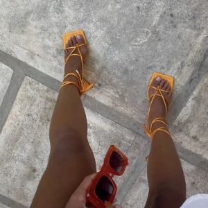 Orangea klackskor - Supersnygga orangea klackskor med snörning från NA-KD, som jag hade på mitt utspring. Endast använda en gång och i bra skick! Perfekt till sommaren när man är brun!😍🙏🏼
