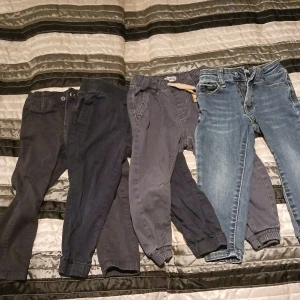 4 jeansbyxor barn - Från vänster: 1mörkblå med knapp storlek 90. 1 mörkblå utan knäppning storlek 92. 1 lite ljusare blå med snörning storlek 92. 1 jeans med knäppning i storlek 92. Använt skick