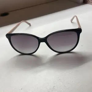 Snygga corlin eyewear solglasögon med rosa detaljer på bågen. 