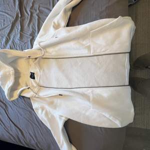 De är en vit zip-hoodie som är i nyskick, den är knappt använd har bara kört den i tvätten 2-3 gånger. Jag tänkte ha kvar den men den skräpar bara i garderoben då jag inte tycker om att den är så vit. Köpte den i en affär i Göteborg för 2 veckor sedan.