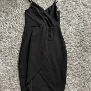Svart klänning  - Använd fåtal gånger, bra skick. Fin form på kroppen pga utformningen 