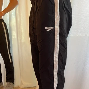 Reebok byxor - Vindbyxa/Joggers från Reebok. Finns möjlighet att dra ihop byxorna nedtill med gummiband. Storlek L. Pris kan diskuteras vid snabb affär. Frakt tillkommer. 
