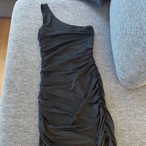 Klänning - En superfin svart one-shoulder klänning! Svårt att förklara materialet men skulle säga lite satin liknande! Formar kroppen underbart! Aldrig använd. Storlek xs men passar s då den är stretchig. 50kr plus frakt!💕