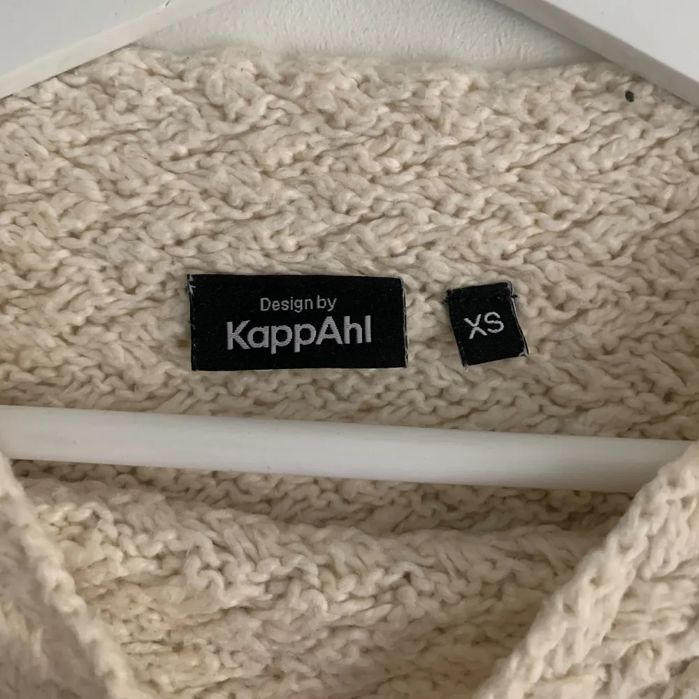 En stickad tröja i bomull från Kappahl. Cremevit färg.   Bra kvalitet, sparsamt använd, inga defekter.   Axelmått: 42cm Längd: 55 cm. Stickat.