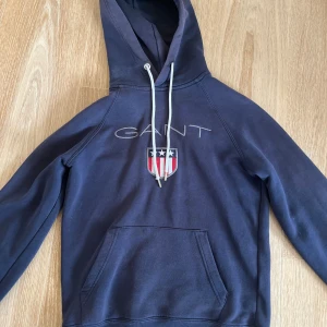Gant hoddie - Säljer en snygg gant hoddie i färgen mörkblå för bra pris! Hoddien är i skick 9/10 och har storleken XS.