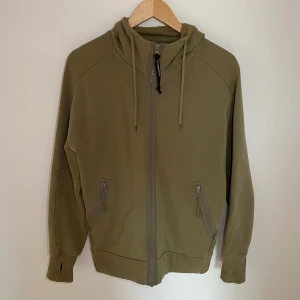 Cp company zip hoodie - Cp company zip hoodie i bra skick. Storlek M, skick 8/10 inte ny men i bra skick. Säljes då den var för liten. Nypris 3k.  Pris går att diskutera 