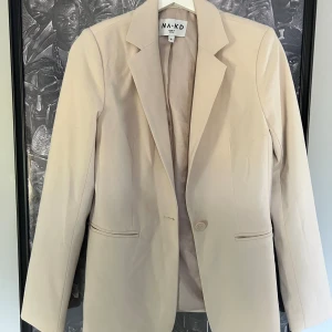 Beige kavaj från Nakd - Superfin beige kavaj från Nakd. Säljer pga att jag inte använder den länge. Storlek 36