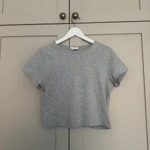 Grå, basic, croppad t-shirt från Gina Tricot! Passar storlekarna XS-XL beroende på hur man vill att den ska sitta på kroppen.💕