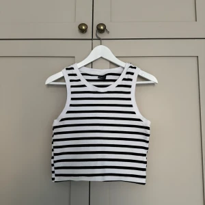 Croppat linne - Croppat, randigt linne i ribbat tyg från Gina Tricot. Perfekt till sommaren!! Storlek XL, men passar mig som vanligtvis har S/M. 