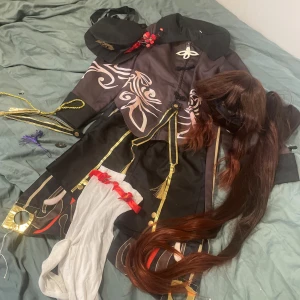 Hu Tao cosplay - Denna cosplay saknar många accessoarer som t.ex den röda skjortan och saken som ska vara på dragkedjan, ja gjorde en egen av papper istället och tejpade på (4 bilden). På den 3 bilden är accessoarerna som ja inte vet vart de ska vara. Peruk är bra 😎