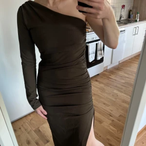 Enärmad klänning - Säljer den här skitsnygga klänningen från Zara. Figurnära passform med rynkdetaljer. Vadlång med slits. Med dold dragkedja så man kommer i den lätt. Strl M men är liten i strl, passar snarare S.