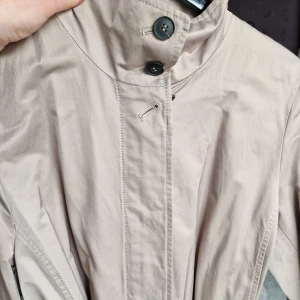 Snygg trenchcoat från Fuchs Schmitt  - Helt nya, oanvänd. Storlek 40.