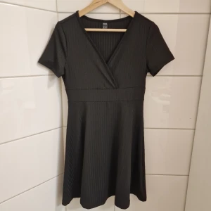 Klänning (Oanvänd) Strl M - Klänning  Strl M Oanvänd! Färg: Svart Shein  Fin kort klänning i smickrande klassisk modell. Kortärmad, i ribbad skön kvalitet.