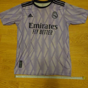 Real Madrid 22/23 bortatröja - Real Madrid 22/23 bortatröja. Köpt från Adidas hemsida och i 9/10 skick då den bara har använts ungefär 4 gånger eftersom att jag köpte Real Madrids 23/24 hemmatröja istället. Säljs p.g.a garderobrensning.