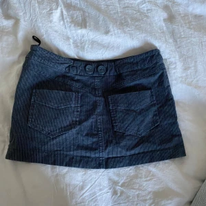 Low waist minikjol - Säljer min jättefina minikjol i nyskick då den tyvärr inte passade mig. Den är inte använd. Kjolen är i storlek xs och lågmidjad med jättegulliga detaljer. Skriv för mer bilder!❤️