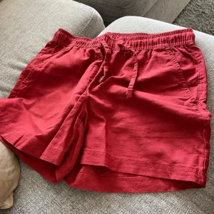 Shorts i linneblandning - Snygga shorts i en mörkröd färg med dragsko i midjan. Shortsen har två fickor framtill och fickor baktill.  Nyskick. Använd 2 gånger. Hel och ren(nyligen tvättad) Storlek 36. Normal i storleken