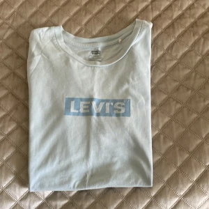 Levis ljusblå T-shirt - Levis ljusblå T-shirt i fint skick! Sparsamt använd, storlek xxs men passar xs/s dam