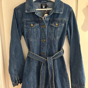 Oanvänd jeansklänning - Helt ny, oanvänd jeansklänning säljes. Den är i strl 38 och sitter perfekt på mig som vanligtvis har strl 34, men jag tyckte den var för kort. Lapparna sitter kvar.