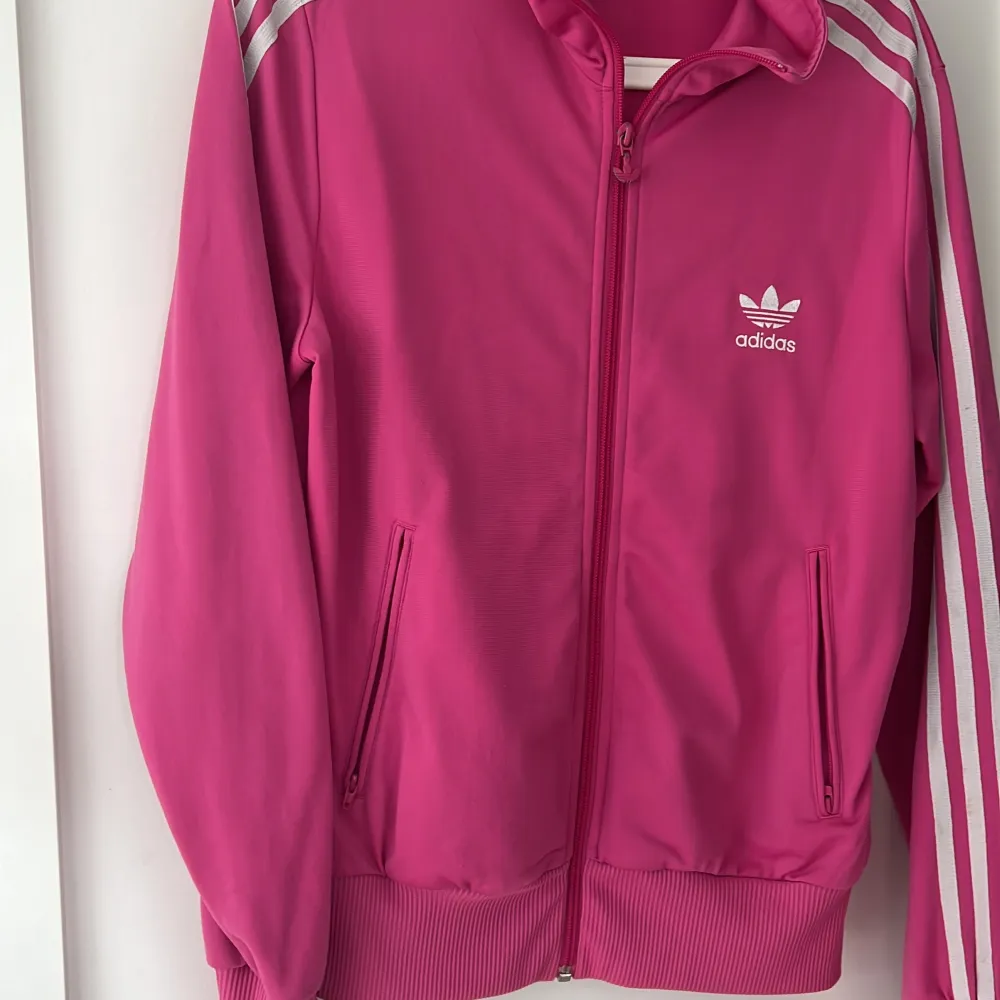 En adidas ”jacka” från 2000 talet som jag och min syster haft. Väldigt bra nyskick och tvättad. Dock tappat lite färg på dragkedjan som är rosa, men inte märkvärdigt.. Jackor.