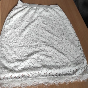 Vit kjol - Vit kjol med spets. Den är lite stretchig i midjan. Storlek S från Lindex.