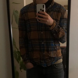Flanellskjorta  - En flanellskjorta från weekday i fint skick, lite skrynklig på bilden men utöver det inga defekter! Passar som en size M ska passa. Själva hudvudfärgen är ljusbrun med gula inslag. Ställ gärna frågor!