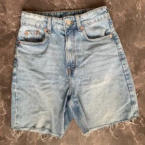 Blåa jeansshorts - Högmidjade blåa jeansshorts från HM. Har en liten fläck på baksidan men är annars i bra skick.  📏Midjemått tvärs över: 30 cm📏 💕Skriv om ni undrar nåt💕 💸Priset går att diskutera💸