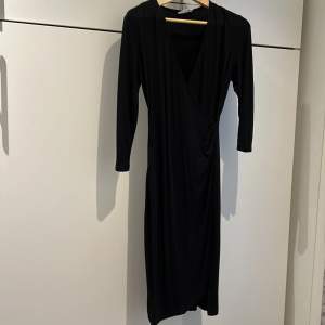 Lång svart v-ringad klänning med tre kvarts ärm. Fin 