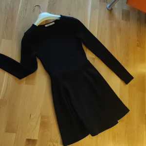 Kort ribbstickad klänning - Kort, svart ribbstickad klänning. Smal i midjan och ärmarna men mer utställd över häften, superfin! Rundad halslinning. Använd ett fåtal gånger.  Kan mötas upp i lund, annars står köparen för frakten 🌸