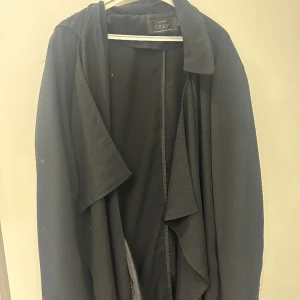 Trenchcoat - Svart trenchcoat från only strl 36, sömmar som gått upp på ena armen säljes därför billigt annars fin jacka