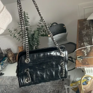 Handväska från Zara - Helt oanvänd handväska från Zara. Rimlig med liten. Har en ficka inuti. Svart men glänser som läder.